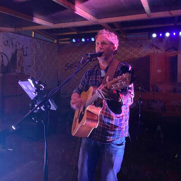 ChordReactn: Sänger mit Akustikgitarre im violetten Bühnenlicht, secret stage, Kieler Woche 2025