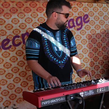 Keyboarder mit Sonnenbrille vor dem secret stage Schriftzug, Kieler Woche 2024