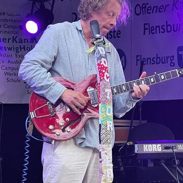 Gitarrist mit roter E-Gitarre auf der Bühne des Offenen Kanals, secret stage, Kieler Woche 2023