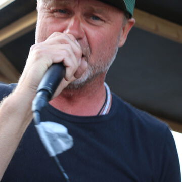 Sänger mit Basecap singt ins Mikrofon, secret stage, Kieler Woche 2023