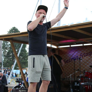 Sänger reißt auf der Bühne den Arm hoch, secret stage, Kieler Woche 2023
