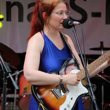 Sängerin mit roten Haaren und E-Gitarre auf der Bühne des Offenen Kanals, secret stage, Kieler Woche 2023