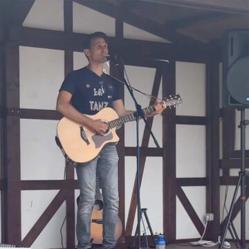 start.button.jetzt: Sänger mit Akustikgitarre auf der secret stage, Kieler Woche 2025