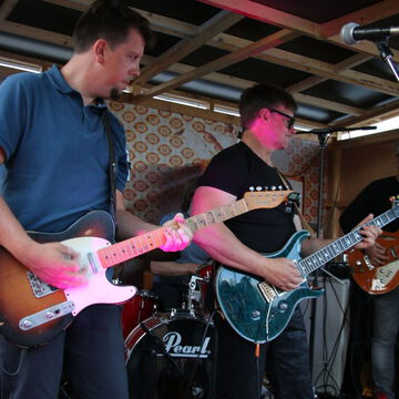 Gitarristen mit pinker und blauer E-Gitarre auf der secret stage, Kieler Woche 2023