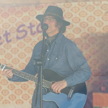 Sänger mit Hut und Akustikgitarre am Mikrofon, secret stage, Kieler Woche 2025