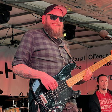 Bassist mit Bart, Basecap und Sonnenbrille auf der secret stage, Kieler Woche 2024