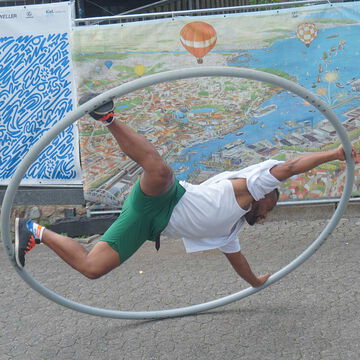 Artist turnt im Cyr-Rad vor einer Kiel-Karte, Kiel Artist, Kieler Woche 2025
